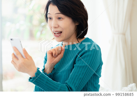 Middle women playing smartphone games 99158685