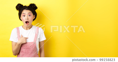 Surprised asian teen girl with glamour makeup, pointing at herself and gasping confused, being chosen or accused, standing on pink background Surprised asian teen girl with glamour makeup, pointing at herself and gasping confused, being chosen or accused, standing on pink background 99158823
