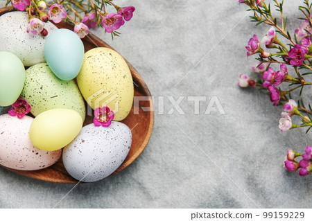Easter decor. Colored Easter eggs on a wooden plate on the table. Easter decor. Colored Easter eggs on a wooden plate on the table. 99159229