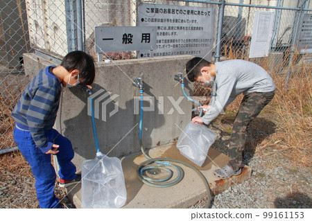 一名小學生在當地政府經營的免費溫泉站汲取溫泉水。 一名小學生在當地政府經營的免費溫泉站汲取溫泉水。 99161153