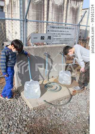 一名小學生在當地政府經營的免費溫泉站汲取溫泉水。 99161154