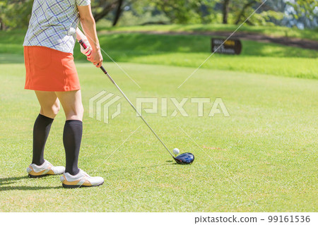 A golfer's woman playing golf on a golf course (foot, tee shot, golf competition) 99161536
