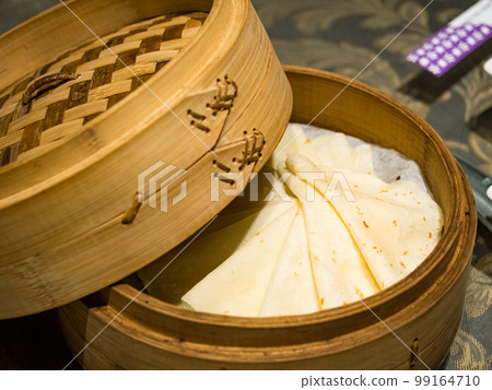Steamed burritos stuffed with meat in a bamboo steamer. Steamed burritos stuffed with meat in a bamboo steamer. 99164710
