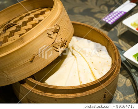 Steamed burritos stuffed with meat in a bamboo steamer. Steamed burritos stuffed with meat in a bamboo steamer. 99164713