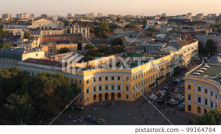 View from drone of urban street scape and buildings. Many people walking around. 99164784