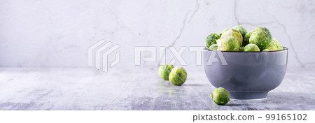 A bowl of frozen brussels sprouts on the table. Vegetable diet. Web banner A bowl of frozen brussels sprouts on the table. Vegetable diet. Web banner 99165102