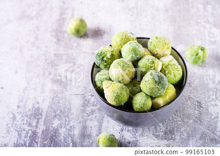 A bowl of frozen brussels sprouts on the table. Vegetable diet. 99165103
