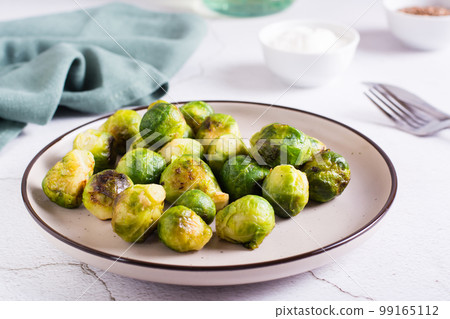 Roasted Brussels sprouts on a plate on the table. Vegetarian diet. 99165112
