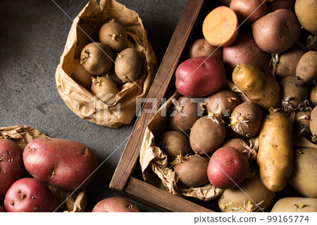 Different varieties of potatoes in a wooden box 99165774
