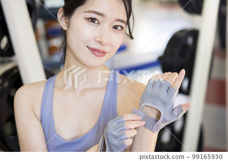 Young woman wearing training gloves at the gym 99165930