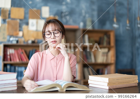 A young woman reading 99166264