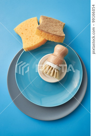 Cleaning set for different surfaces in kitchen, bathroom and other rooms. Empty place for text or logo on blue background. Cleaning service concept. Early spring regular clean up. Front view. Cleaning set for different surfaces in kitchen, bathroom and other rooms. Empty place for text or logo on blue background. Cleaning service concept. Early spring regular clean up. Front view. 99166854