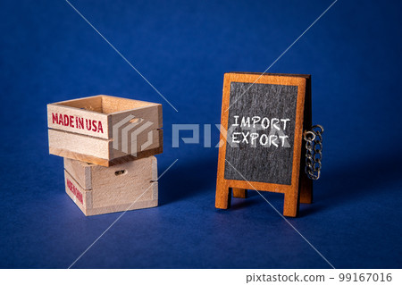 Import Export Concept. Miniature chalk board and wooden boxes on a blue background Import Export Concept. Miniature chalk board and wooden boxes on a blue background 99167016