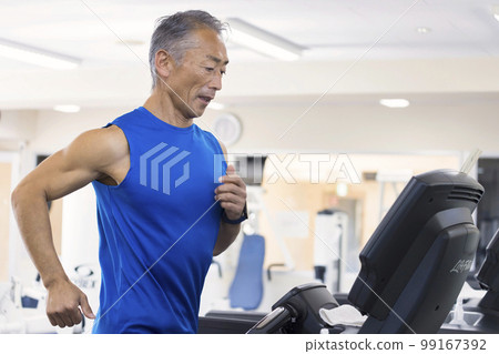 Middle-aged man running on a running machine in the gym 99167392