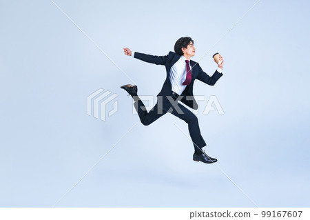 Young businessman jumping with coffee cup Young businessman jumping with coffee cup 99167607