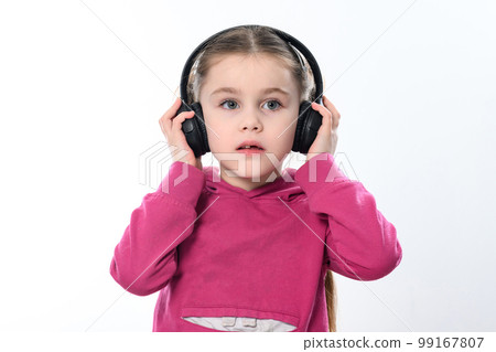 A child with headphones on a white background, a cheerful and beautiful girl with headphones. 99167807