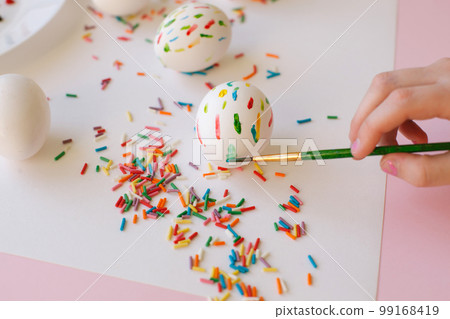 A ten-year-old girl decorates an egg for Easter. Close-up. 99168419