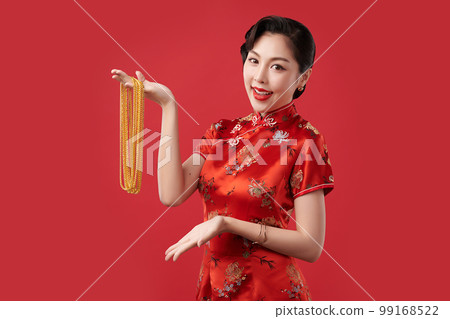 Chinese new year festival, Beautiful Young asian woman wearing traditional cheongsam qipao dress with gold necklaces on red background, 99168522