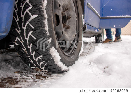 Blue car standing in the snow closeup Blue car standing in the snow closeup 99168999