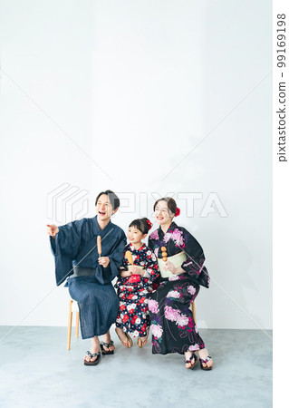 穿著浴衣吃街頭小吃的父母和孩子 99169198