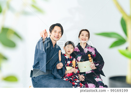 Parents and children eating street food in yukata 99169199
