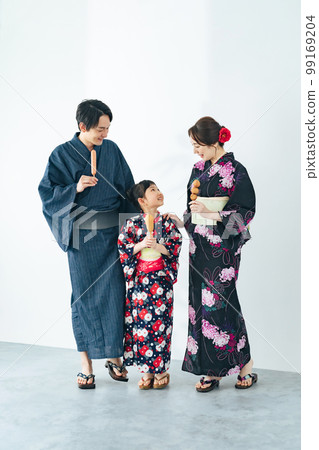 穿著浴衣吃街頭小吃的父母和孩子 穿著浴衣吃街頭小吃的父母和孩子 99169204
