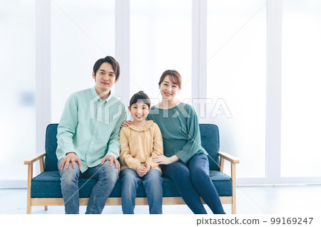 父母和孩子並排坐在沙發上 父母和孩子並排坐在沙發上 99169247