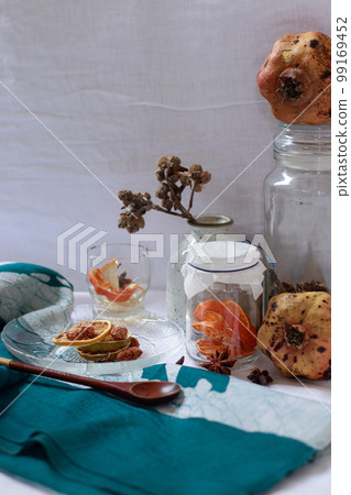 Vertical shot of pomegranate, lemon slices and aromatic herbs for a relaxing aromatherapy session at home 99169452