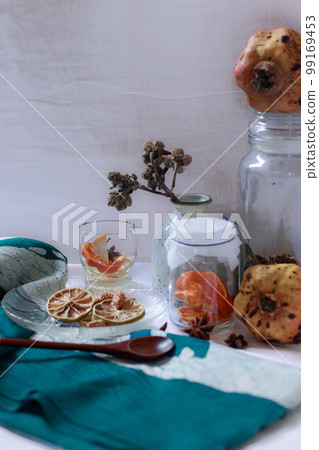 Vertical shot of pomegranate, lemon slices and aromatic herbs for a relaxing aromatherapy session at home 99169453