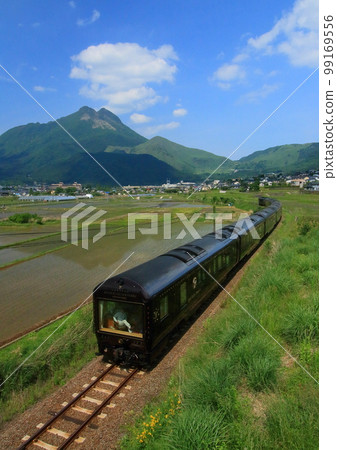 Cruise train "Seven Stars in Kyushu" traveling through the Yufuin Basin (vertical composition) 99169556
