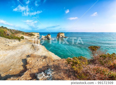 Picturesque seascape with white rocky cliffs, sea bay, islets and faraglioni near by beach Spiaggia della Punticeddha, 99172309