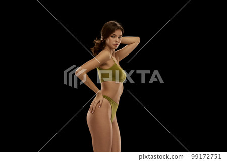 Portrait of young attractive woman posing in olive color lingerie isolated over black background. Concept of beauty, body and skin care, health, plastic surgery, cosmetics, ad 99172751