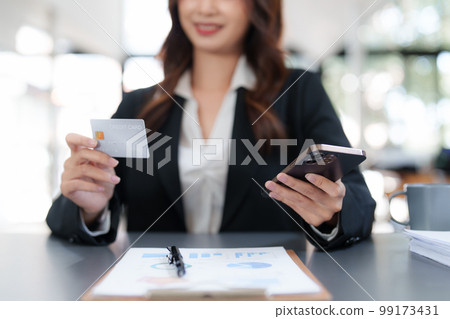 Woman makes a purchase on the smart phone with credit card, online payment, shopping online, e-commerce, internet banking concept Woman makes a purchase on the smart phone with credit card, online payment, shopping online, e-commerce, internet banking concept 99173431