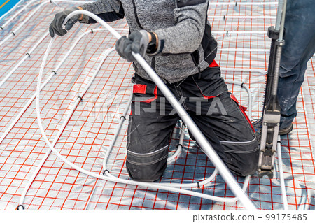 manual installation of underfloor heating in a new building. professional worker 99175485