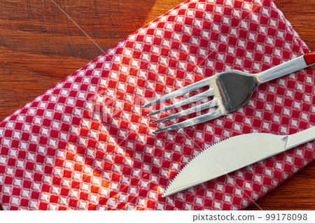 Red checkered napkin or tablecloth on wooden table Red checkered napkin or tablecloth on wooden table 99178098