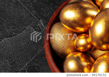 Golden Easter eggs on a black concrete background Golden Easter eggs on a black concrete background 99178132