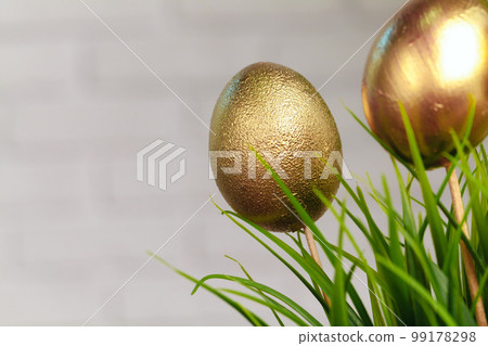 Golden colored Easter eggs stuck to artificial grass Golden colored Easter eggs stuck to artificial grass 99178298
