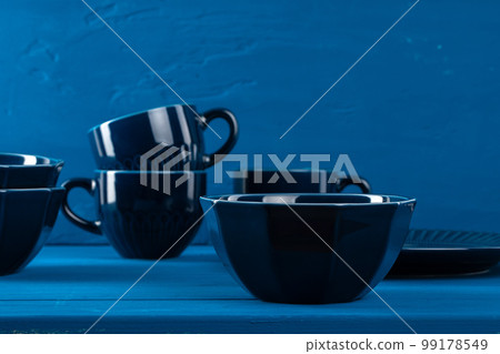 Dark blue crockery on blue wooden background 99178549