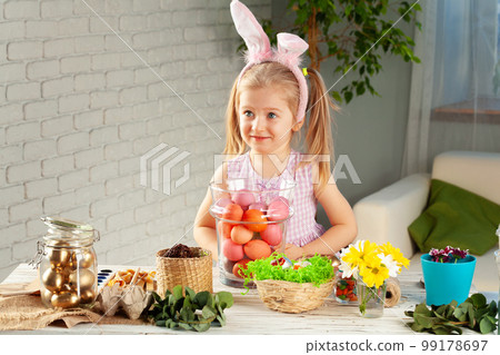 Happy little girl with bunny ears getting ready for Easter party Happy little girl with bunny ears getting ready for Easter party 99178697