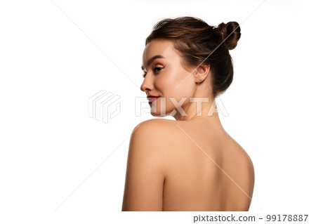 Side view portrait. Naked shoulders. One beautiful brunette girl posing against white studio background. Concept of natural beauty 99178887
