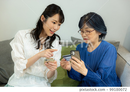A senior woman and a young woman in the living room A senior woman and a young woman in the living room 99180072