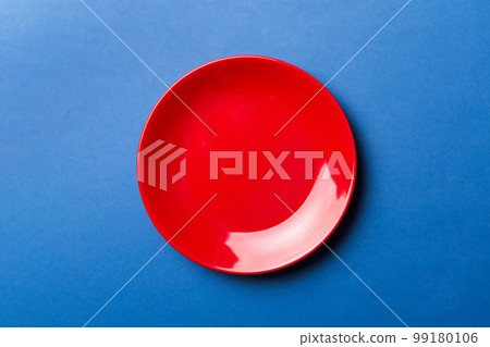 Top view of isolated of colored background empty round red plate for food. Empty dish with space for your design Top view of isolated of colored background empty round red plate for food. Empty dish with space for your design 99180106
