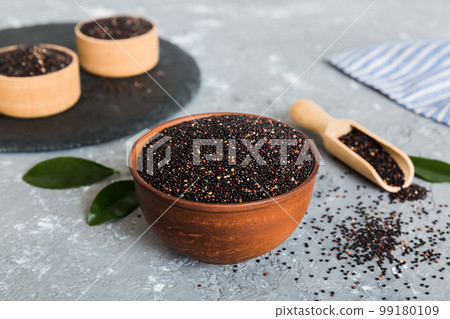 quinoa seeds in bowl and spoon on colored background. Healthy kinwa in small bowl. Healthy superfood quinoa seeds in bowl and spoon on colored background. Healthy kinwa in small bowl. Healthy superfood 99180109