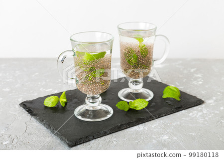 Healthy breakfast or morning with chia seeds and mint on table background, vegetarian food, diet and health concept. Chia pudding with and mint Healthy breakfast or morning with chia seeds and mint on table background, vegetarian food, diet and health concept. Chia pudding with and mint 99180118