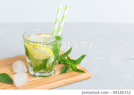 Mojito summer refreshing cocktail with ice and mint. mojito cocktail with lime, lemon and mint in a tall glass with a stick 99180152