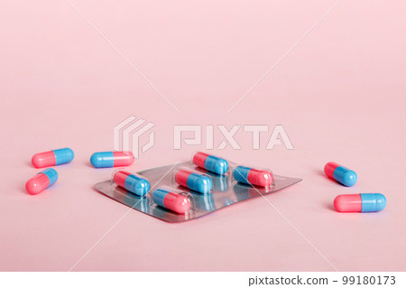 Medicine pills on a light background. Medicines and prescription pills flat lay background. Blue and pink medical tablets in blister 99180173
