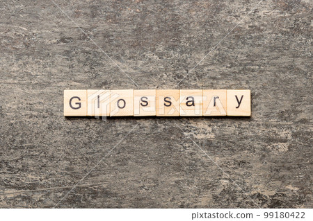 Glossary word written on wood block. Glossary text on cement table for your desing, Top view concept Glossary word written on wood block. Glossary text on cement table for your desing, Top view concept 99180422
