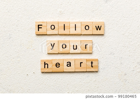Follow your heart word written on wood block. Follow your heart text on cement table for your desing, Top view concept Follow your heart word written on wood block. Follow your heart text on cement table for your desing, Top view concept 99180465