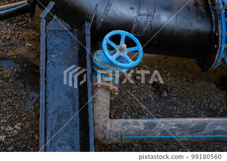 Blue valve close-up on the drain tube in the well. Blue valve close-up on the drain tube in the well. 99180560