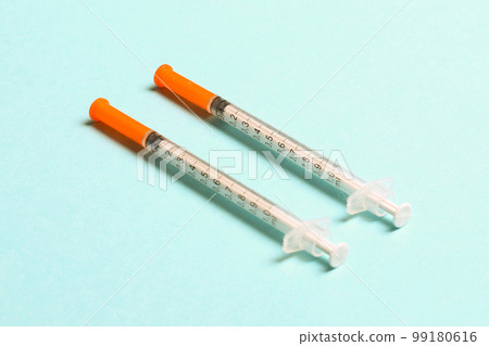 Top view of two insulin syringe at colorful background with copy space. High level of glucose concept Top view of two insulin syringe at colorful background with copy space. High level of glucose concept 99180616